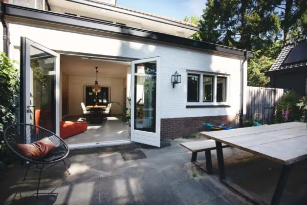 Doorkijk vanuit tuin naar woonkamer met tuindeuren – jaren ’30 woning Kerckebosch Zeist