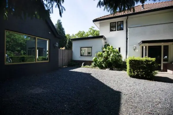 Oprit met grind en zicht op gerenoveerde woning – jaren ’30 woning Kerckebosch Zeist