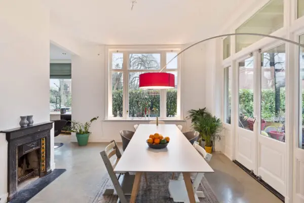 Eetkamer met houten tafel en rode booglamp villa Rijsenburgselaan Driebergen