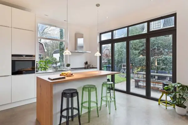 Luxe keuken met kookeiland en barkrukken villa Rijsenburgselaan Driebergen