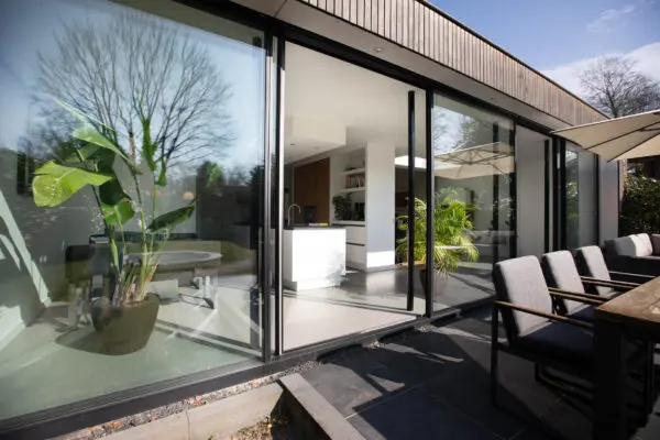 Moderne uitbouw met glazen schuifpui en zithoek – jaren ’30 woning Wilhelminapark Zeist
