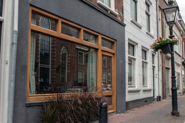 Straatbeeld met gerenoveerde gevel en houten kozijnen – centrum Utrecht