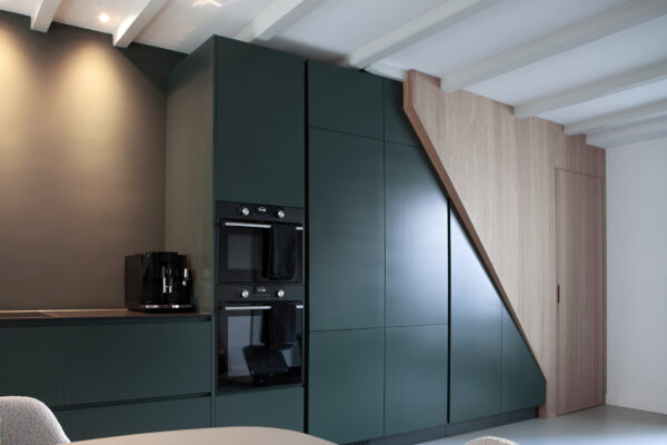 Keuken met donkergroene kastenwand en houten trap – centrum Utrecht