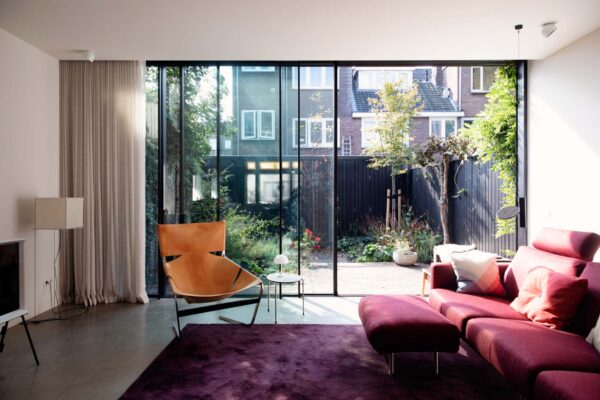 Zithoek met bank en vloerlamp bij raam – jaren ’30 woning Tuinwijk Oost Utrecht