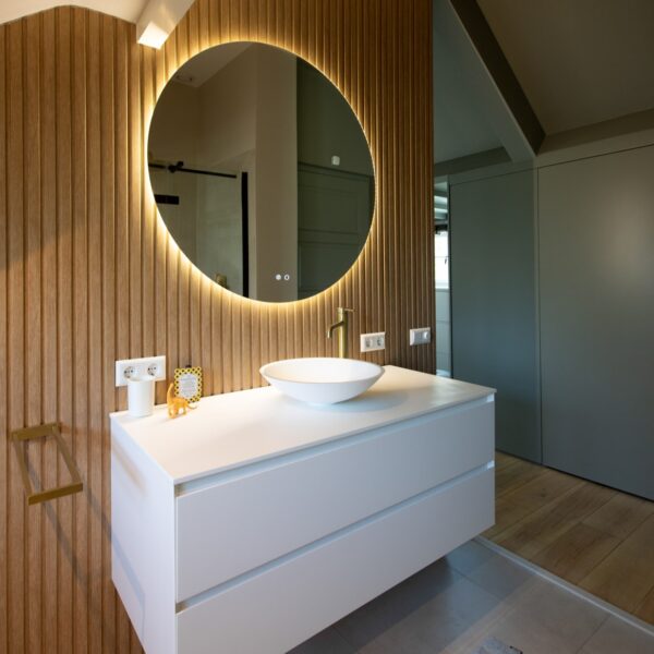 Moderne badkamer met wastafelmeubel en ronde spiegel – villa Het Gooi