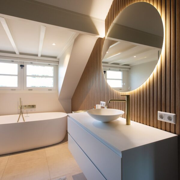 Badkamer met vrijstaand ligbad en ronde spiegel – villa Het Gooi