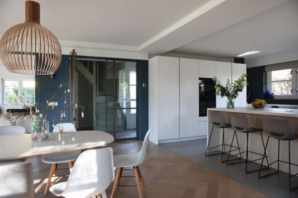 Eetkamer met grote ramen en designlamp – villa Het Gooi