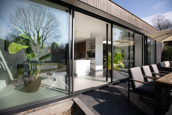 Moderne uitbouw met glazen schuifpui en zithoek – jaren ’30 woning Wilhelminapark Zeist